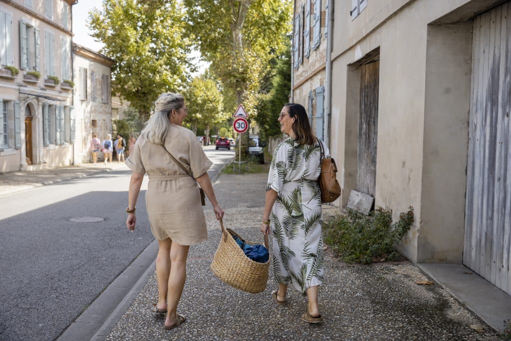 Teacher and student walking through a French village with a market basket
